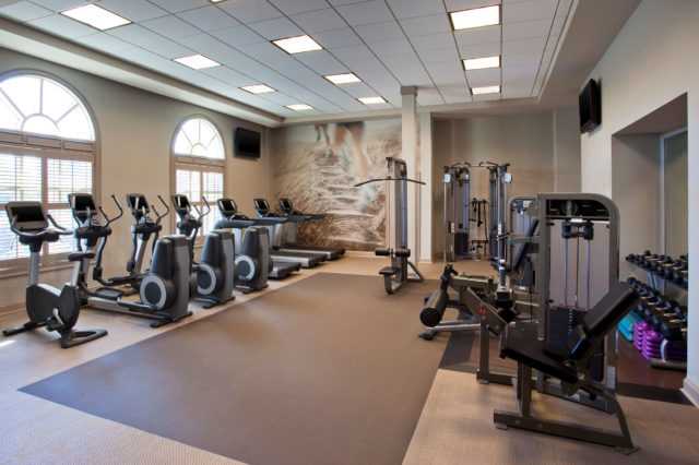 the fitness room equipped with treadmills, weights and bicycles