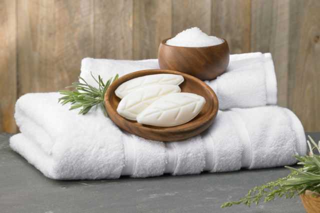bars of soap held in wooden bowls on top of fresh towels