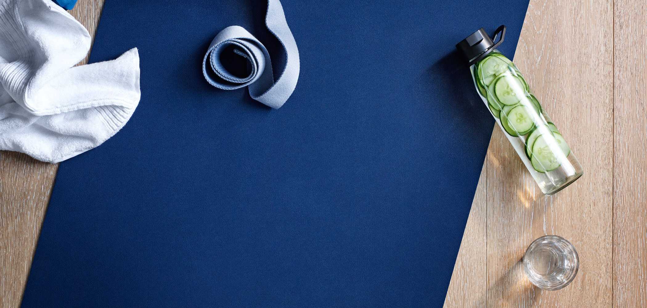 a yoga mat with a water bottle infused with cucumber
